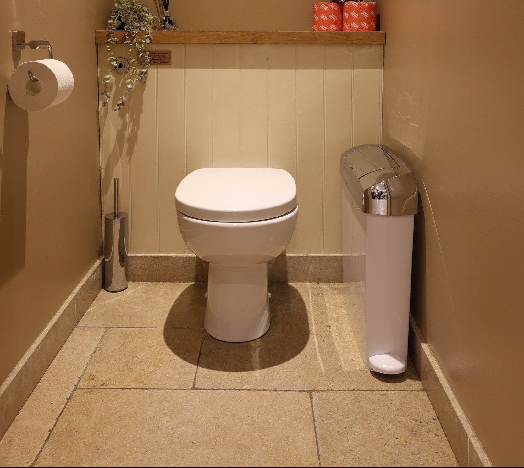 Sanitary bin in white and chrome fitted in a WC cubicle