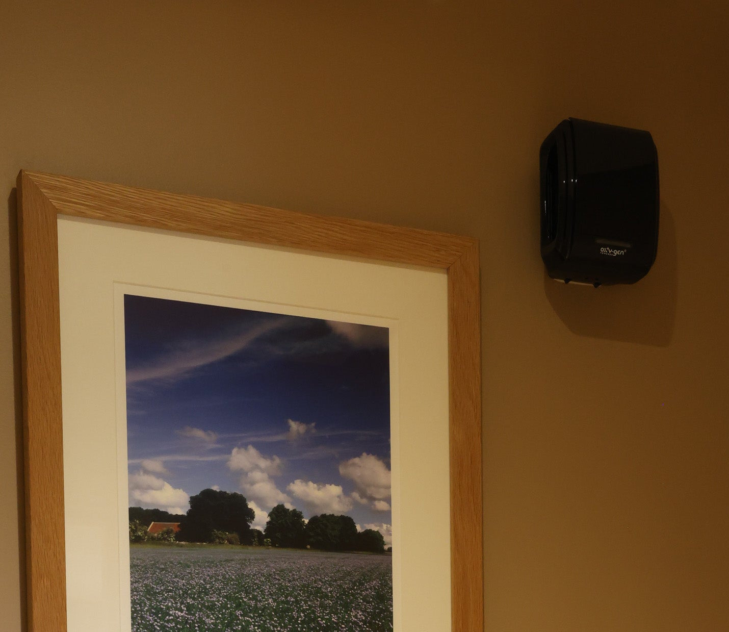 Air hygiene services: Oxy-gen Supreme dispenser in black on a washroom wall