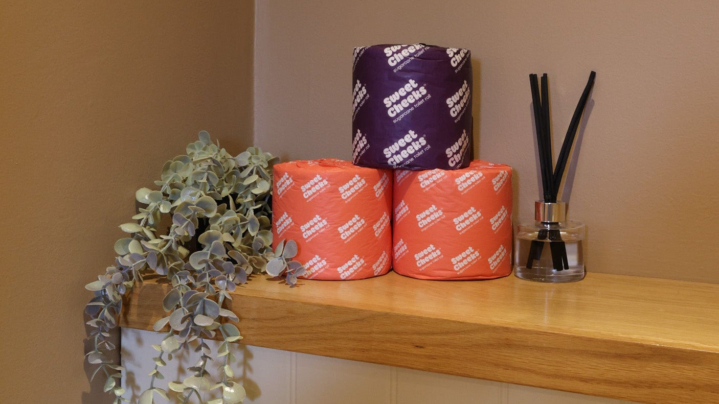 Sugarcane toilet rolls, 3-ply and 5-ply, stacked on a washroom shelf