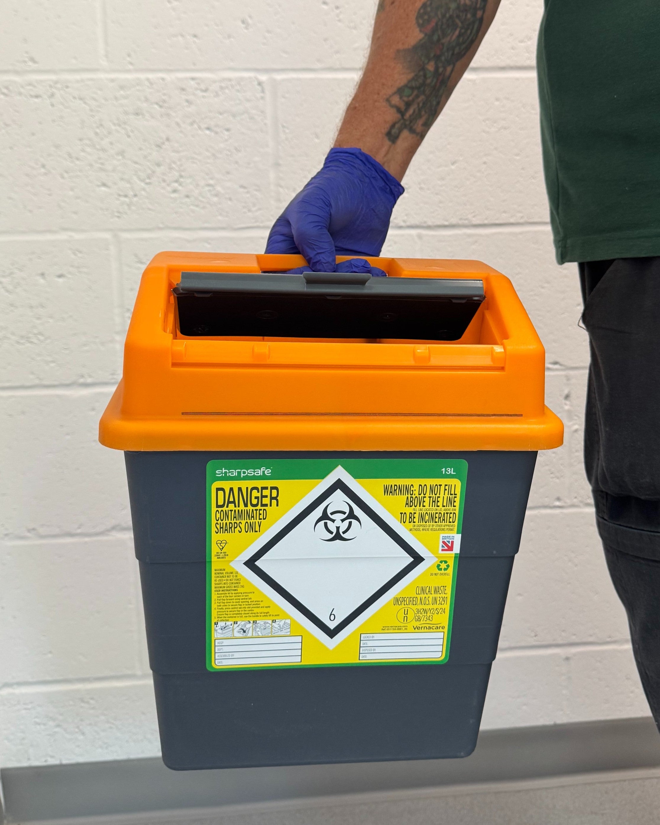 Sharps waste disposal: engineer holding a 13 litre hazardous sharps disposal unit