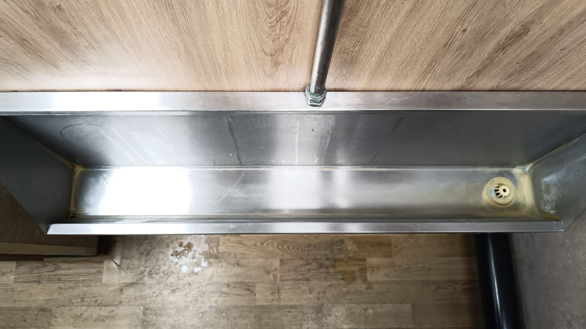 Trough before a deep clean, showing limescale build-up
