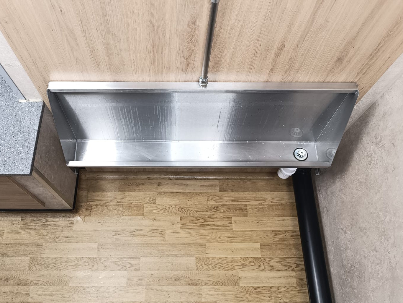 Trough screens: a stainless steel trough on wooden panelling