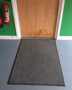 Emmanuel College Cambridge traffic mat fitted infront of a door in grey