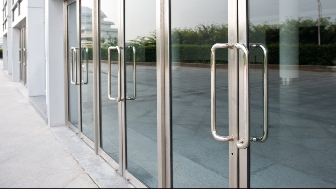 Logo mats: glass entrance doors of a modern commercial building