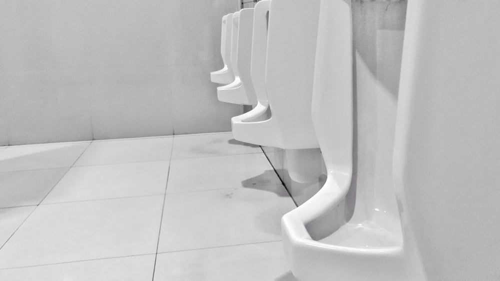 Urinal and WC sanitisers: a row of white urinals in a washroom