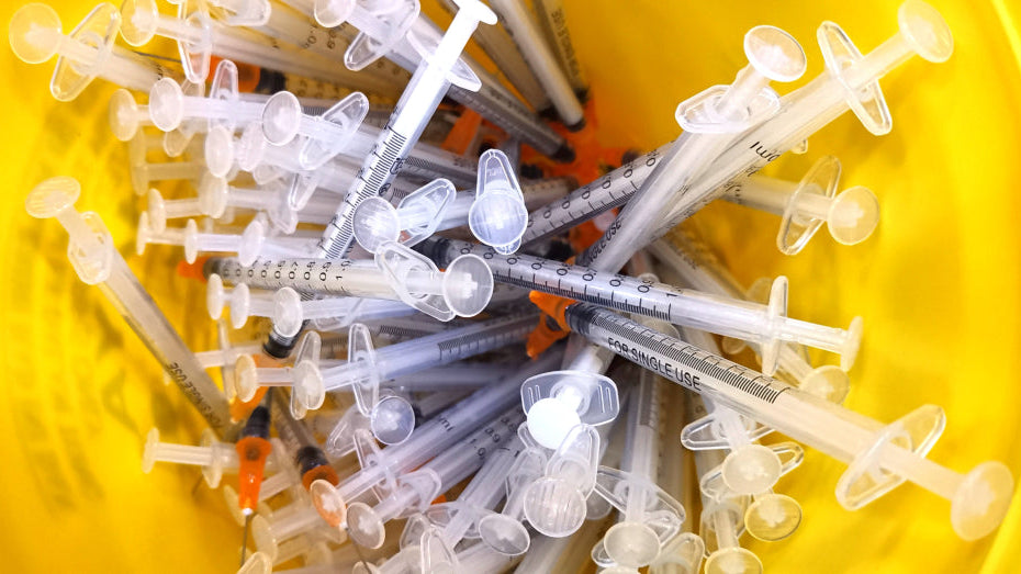 Sharps disposal: used needles inside a non-hazardous sharps bin