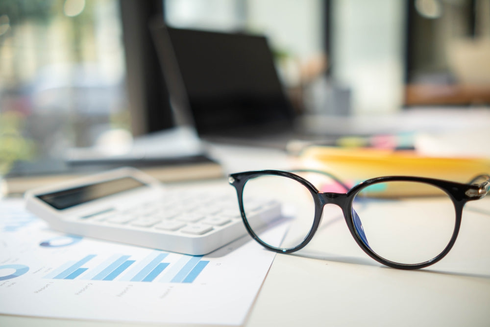 Better value: reading glasses and a calculator on a desk
