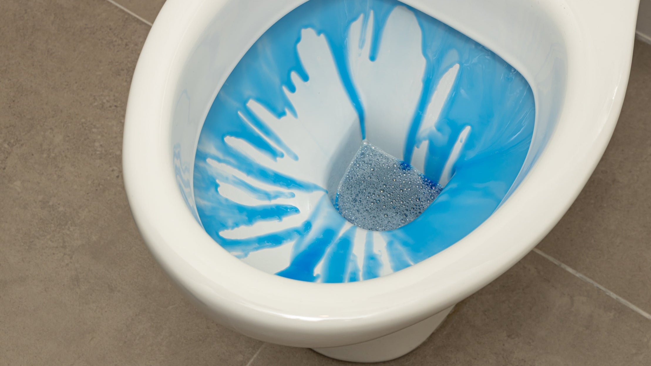 WC deep clean: toilet cleaner running into a toilet bowl