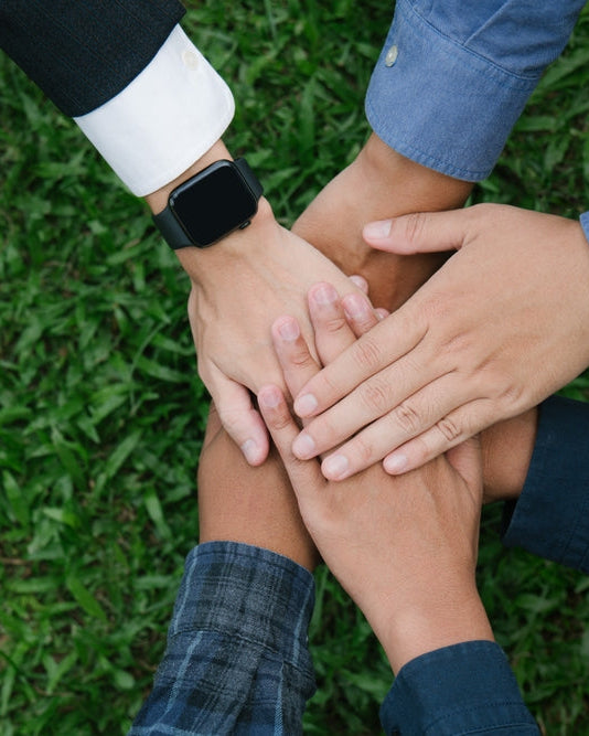 Corporate Social Responsibility Policy: a group with their hands together above green grass