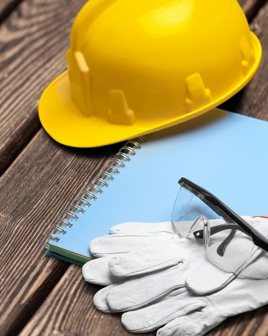 Health and Safety Policy: hard hat, safety glasses and gloves on a workbench